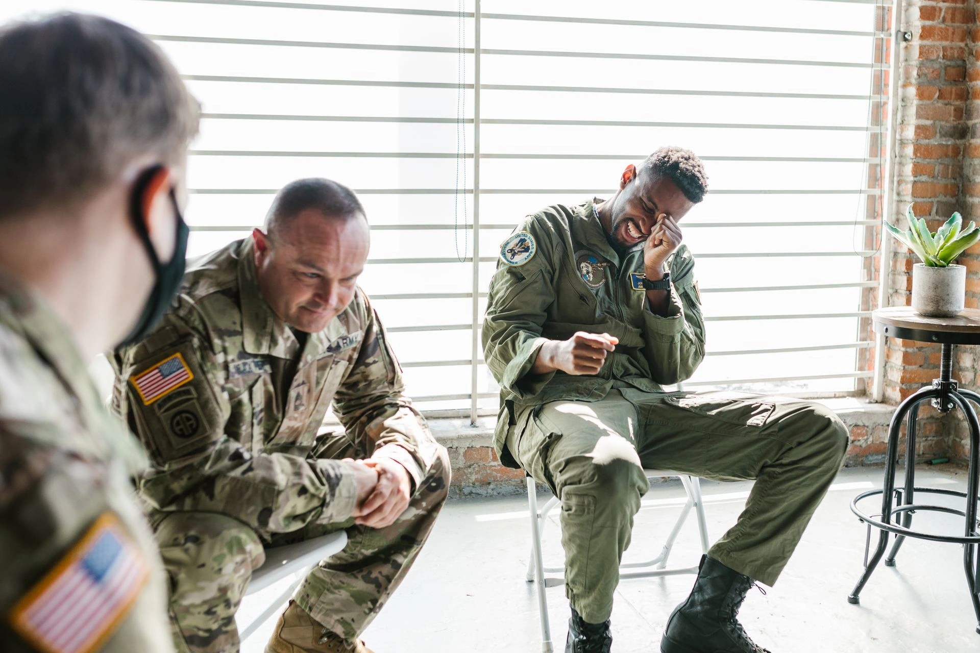 Service members sitting in a group counseling session, one veteran overcome with emotion as the others listen — the kind of honest, shame-free space where recovery from porn addiction begins
